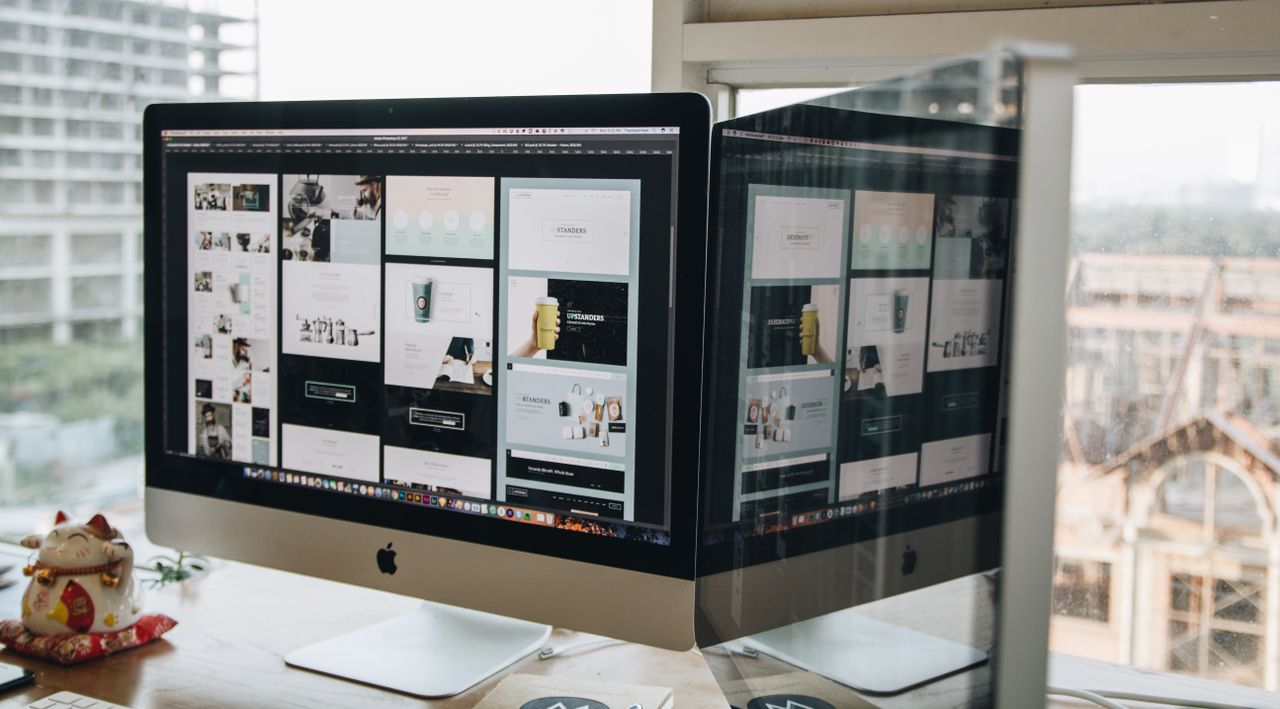Deux écrans posés sur un bureau, illustrant une conception web dans un environnement de bureau moderne.